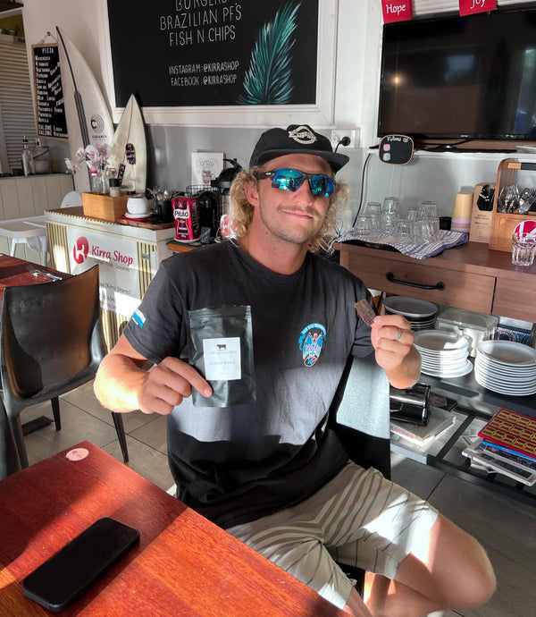 Man holding a coffee package in a cafe setting